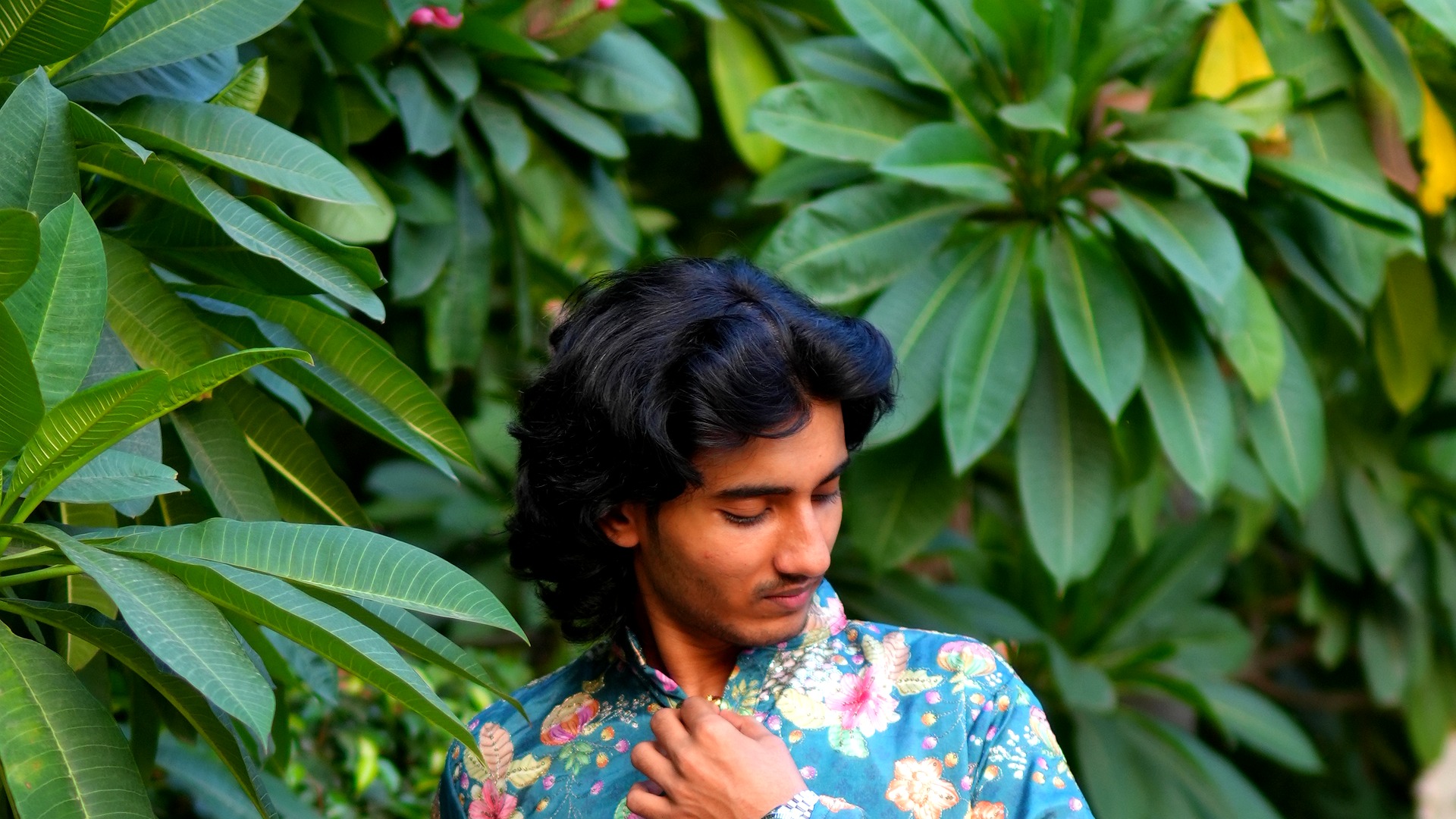 Man wearing an elegant orange kurta in a festive haveli setting